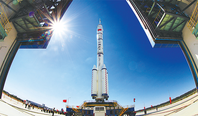 The Shenzhou-9 spacecraft and its carrier rocket, the Long March-2F, are transferred to the launch pad at the Jiuquan Satellite Launch Center in Gansu Province on Saturday. The manned spacecraft is expected to be launched later this month to dock with orbiting Tiangong-1 space lab module. Photo: CFP