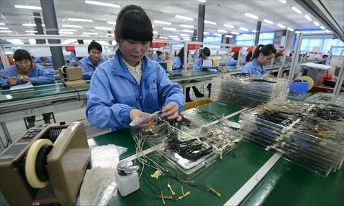 Employees work at a smartphone parts factory in Fuyang, East China’s Anhui Province. Photo: CFP