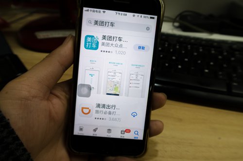 Apps of Didi Chuxing and Meituan Dache are shown on a mobile phone. Photo: VCG