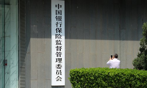A visitor takes photos of the headquarters of China Banking and Insurance Regulatory Commission (CBIRC) in Beijing File photo: IC