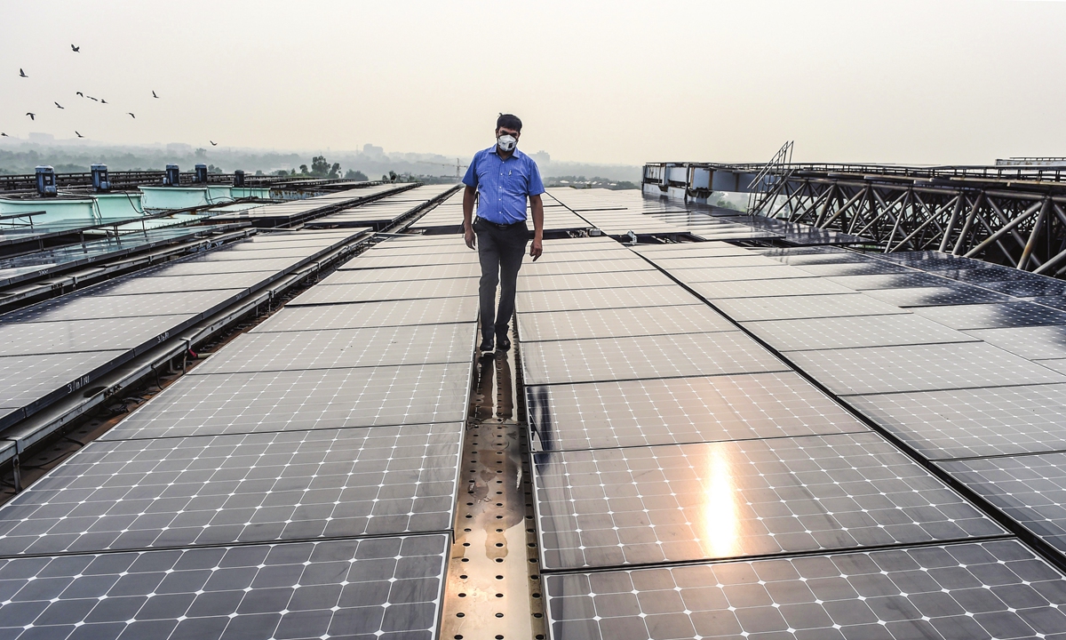 An employee walks among solar panels installed on the Indian Environment Ministry building in New Delhi, India on July 17. Photo: AFP