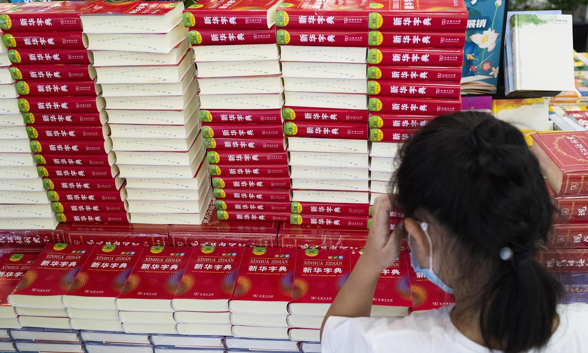 A child reads the new version of the Xinhua Zidian – Xinhua Dictionary (12th Edition) in the Beijing Book Building on Tuesday. The new edition was launched on Monday, adding new words such as chu xin” (mission), dian zan” (thumbs up) and “er wei ma” (QR code), making it the first time that an app and a paper book were issued simultaneously. The Xinhua Zidian is a Chinese language dictionary that was originally published in 1953. It is considered a symbol of Chinese culture. Photo: cnsphoto