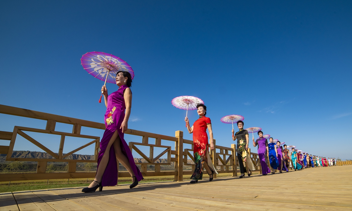 A group of retired women in colorful qipao, also known as cheongsams, walk down the “T stage”, an ecological gallery by the Yellow River, in Central China’s Henan Province. Photo: IC