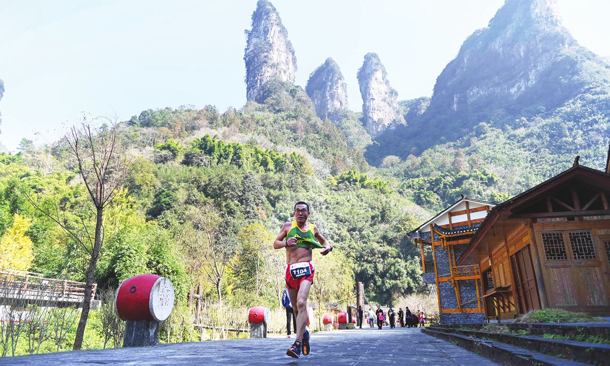 A contestant in a marathon dashes through a village of ethnic Miao people in Jishou, Central China’s Hunan Province on Sunday. Some 1,500 runners joined the race through the mountainous landscape. Photo: cnsphoto 