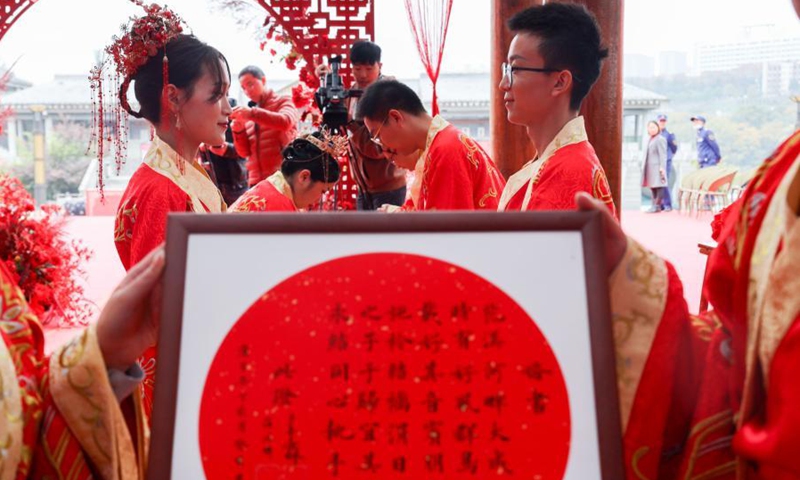 A couple show the certificate for their marriage during a traditional wedding ceremony held in Guiyang, capital of southwest China's Guizhou Province, Nov. 16, 2020. (Xinhua/Ou Dongqu)