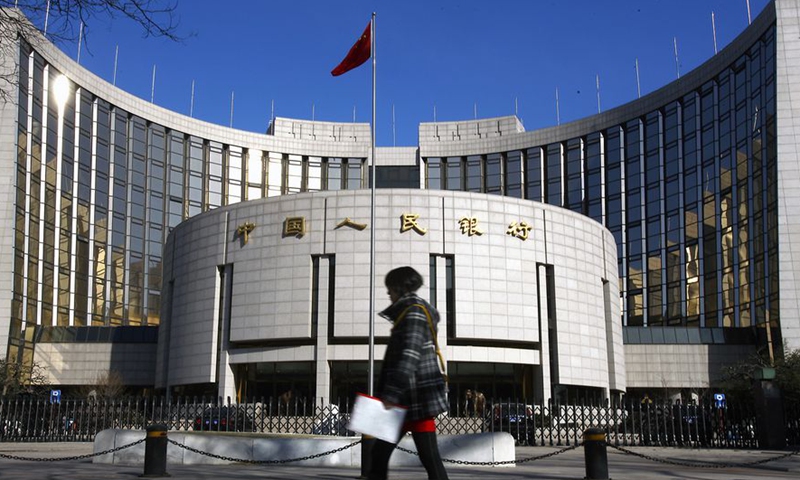 A file photo shows a pedestrian walks past the headquarters building of the People's Bank of China in Beijing, capital of China. (Xinhua)