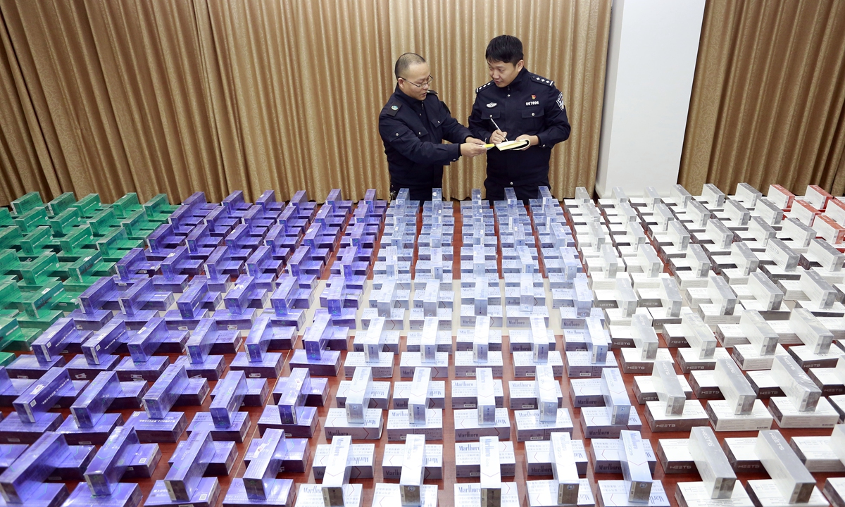 A police officer (right) and a staff member of the tobacco monopoly bureau in Daishan county, East China’s Zhejiang Province count smuggled e-cigarette cartridges. Local police uncovered a case involving smuggling into China and illegal operation of the cigarettes. Police arrested 20 suspects and seized more than 2,000 e-cigarette cartridges with a value of more than 10 million yuan ($1.5 million). Photo: VCG