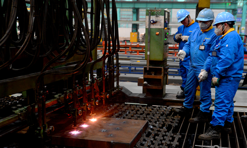 Workers observe the operation of flame cutting equipment at a steel products enterprise in Jingjiang industrial park in Taizhou, East China's Jiangsu province on December 23, 2020. Photo: VCG