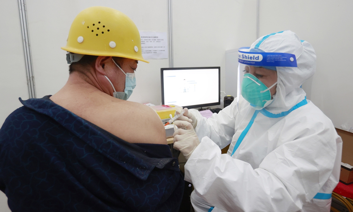 A construction worker for the Beijing Winter Olympic Games venues receives a COVID-19 vaccine on Tuesday in the capital city. Beijing has vaccinated more than 5 million residents and 2.64 million have received two doses. Photo: cnsphoto 
