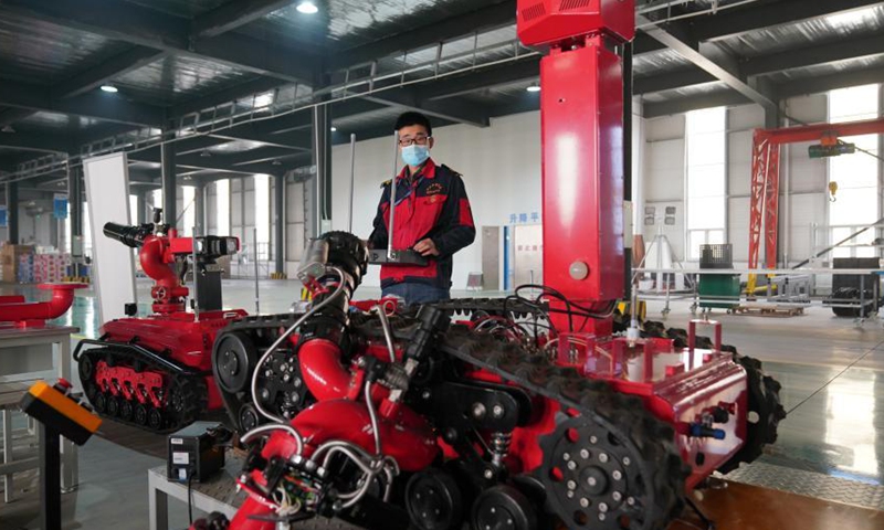 A worker adjusts a robot product in Xingtai City, north China's Hebei Province, March 5, 2021. In recent years, Xingtai Economic Development Area has taken the development of equipment manufacturing industry as an important strategic measure to drive the industrial transformation and upgrading of the whole region. Photo: Xinhua