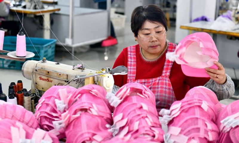 A worker makes hats to be exported to Japan at a manufacturing shop in Ligezhuang Town in Jiaozhou, east China's Shandong Province, March 4, 2021. Over the past 30 years, Ligezhuang Town, a major manufacturing base and collecting and distributing center featuring hat-related products, has achieved industrial upgrading, providing one-stop service for buyers worldwide.Photo:Xinhua
