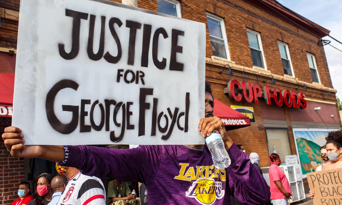 A man holds a sign while protesting near the area where a Minneapolis Police Department officer allegedly killed George Floyd, on May 26, 2020 in Minneapolis, Minnesota.  Photo: VCG