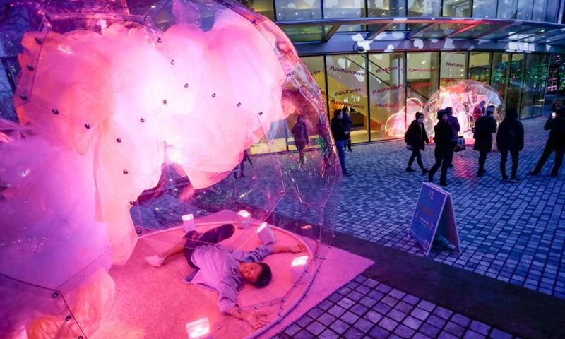 A dancer performs inside a bubble installation during the Dance Bubbles show at Wall Centre Plaza in downtown Vancouver, Canada, March 12, 2021. The show features large brightly-lit bubbles with dancers inside and provides physically distanced entertainment for residents. Photo: Xinhua
