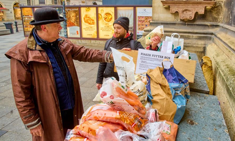 Coachman Hermann Hofer (L) accepts donations for Fiakers horses at the Stephansplatz square in Vienna, Austria, March 19, 2021. Viennese Fiaker coachmen have set up a feed box in the city center, where animal lovers can donate fruit and vegetables for the horses. As one of the most famous tourism projects of Vienna, Fiaker horse carriages encountered operational difficulties during the COVID-19 pandemic.   Photo:Xinhua