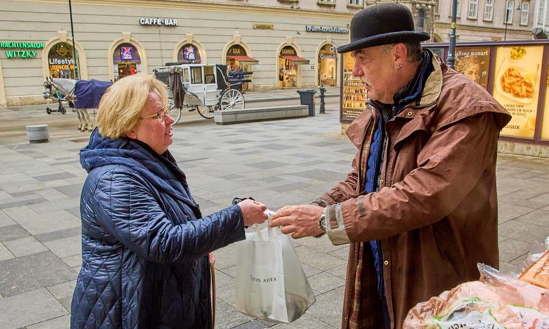 Coachman Hermann Hofer (R) accepts donations for Fiakers horses at the Stephansplatz square in Vienna, Austria, March 19, 2021. Viennese Fiaker coachmen have set up a feed box in the city center, where animal lovers can donate fruit and vegetables for the horses. As one of the most famous tourism projects of Vienna, Fiaker horse carriages encountered operational difficulties during the COVID-19 pandemic.  Photo:Xinhua
