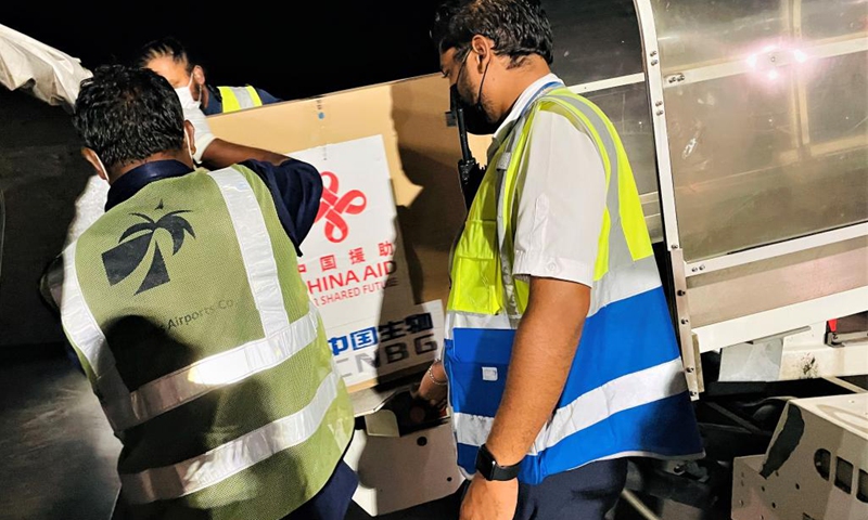 Photo taken with a mobile phone shows staff unloading China-aided COVID-19 vaccines at the Velana International Airport in Male, the Maldives, March 24, 2021. The first batch of vaccines against COVID-19 and anti-epidemic materials donated by China to the Maldives arrived Wednesday night and were handed over on Thursday. Photo:Xinhua