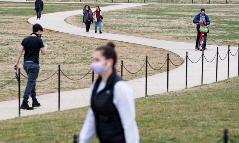 People tour the National Mall in Washington, D.C., the United States, on March 25, 2021. U.S. President Joe Biden announced on Thursday a new goal of administering 200 million COVID-19 vaccine doses to Americans in his first 100 days in office.Photo:Xinhua