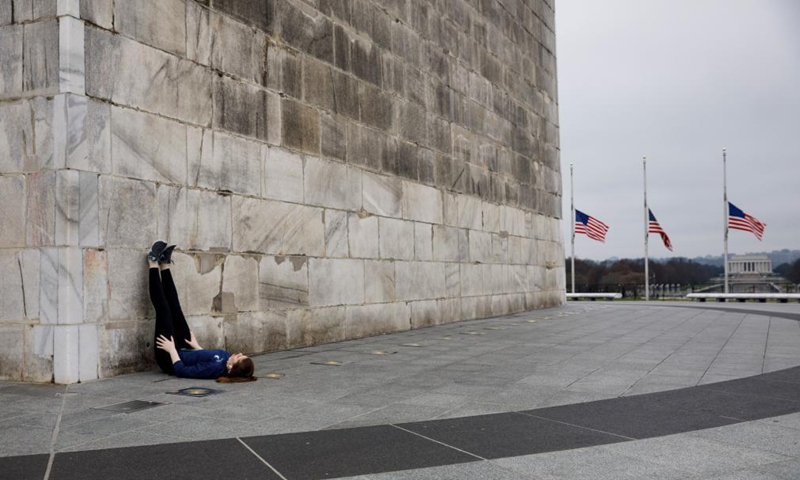 A woman is seen at the Washington Monument in Washington, D.C., the United States, on March 25, 2021. U.S. President Joe Biden announced on Thursday a new goal of administering 200 million COVID-19 vaccine doses to Americans in his first 100 days in office.Photo:Xinhua