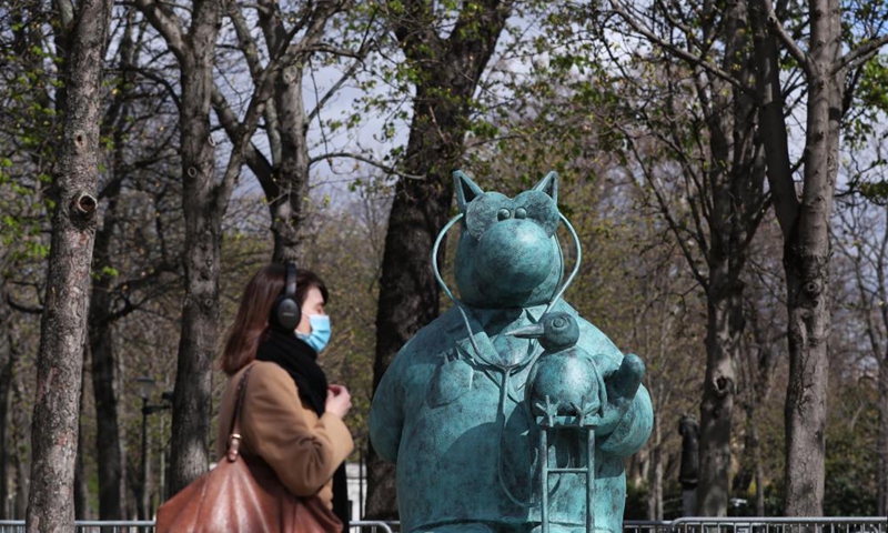 People walk past bronze statues of Belgian cartoonist Philippe Geluck's character from Le Chat (The Cat) on the Champs Elysees in Paris, France, March 26, 2021. An exhibition of 20 bronze statues of Belgian cartoonist Philippe Geluck's character from Le Chat (The Cat) was held Friday on the Champs Elysees of Paris, which will last until June 9, 2021.Photo:Xinhua