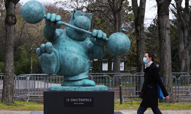 People walk past bronze statues of Belgian cartoonist Philippe Geluck's character from Le Chat (The Cat) on the Champs Elysees in Paris, France, March 26, 2021. An exhibition of 20 bronze statues of Belgian cartoonist Philippe Geluck's character from Le Chat (The Cat) was held Friday on the Champs Elysees of Paris, which will last until June 9, 2021.Photo:Xinhua