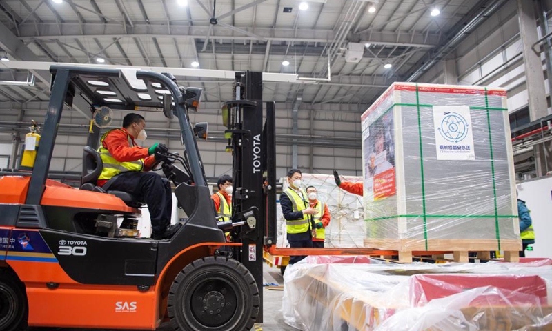 Workers load boxes of Sinovac COVID-19 vaccines onto a pallet at Beijing Daxing International Cargo Terminal of China Southern Airlines in Beijing, capital of China, March 26, 2021. The first chartered international flight with 1.5 million Sinovac COVID-19 vaccines, which was operated by China Southern Airlines, heading for Phnom Penh, Cambodia departed Beijing Daxing International Airport on Friday.Photo:Xinhua