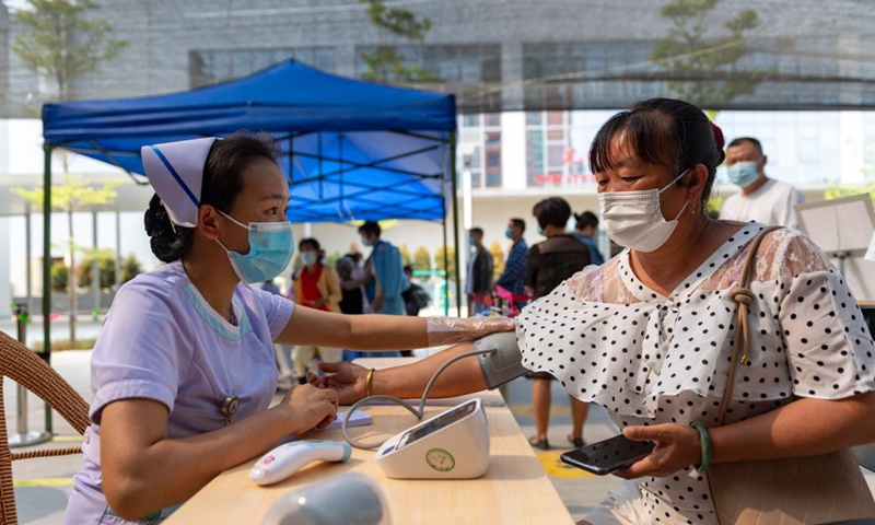 A woman measures blood pressure at a COVID-19 vaccination site of Jingcheng Hospital in Ruili City, southwest China's Yunnan Province, April 1, 2021.Photo:Xinhua