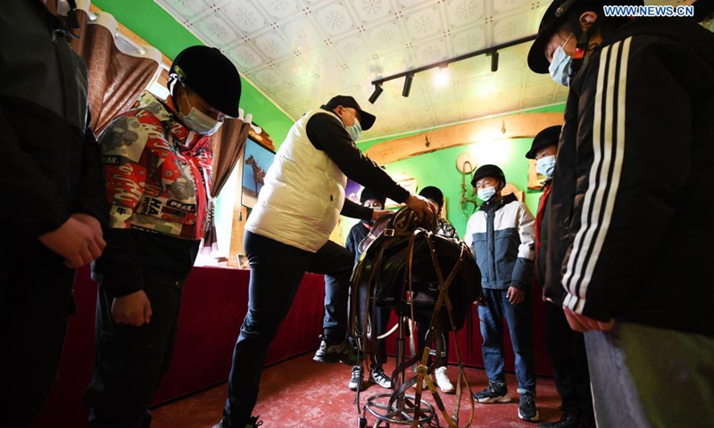 Equestrian coach Abduhyem Abduryem (C) explains knowledge to his students from Oymak Boarding School during an equestrian class in Burqin County, northwest China's Xinjiang Uygur Autonomous Region, March 29, 2021. Photo: Xinhua