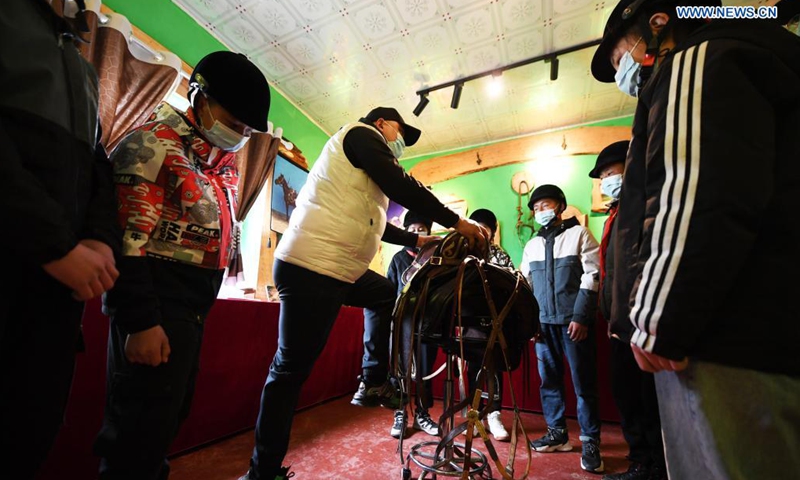 Equestrian coach Abduhyem Abduryem (C) explains knowledge to his students from Oymak Boarding School during an equestrian class in Burqin County, northwest China's Xinjiang Uygur Autonomous Region, March 29, 2021.  Photo: Xinhua