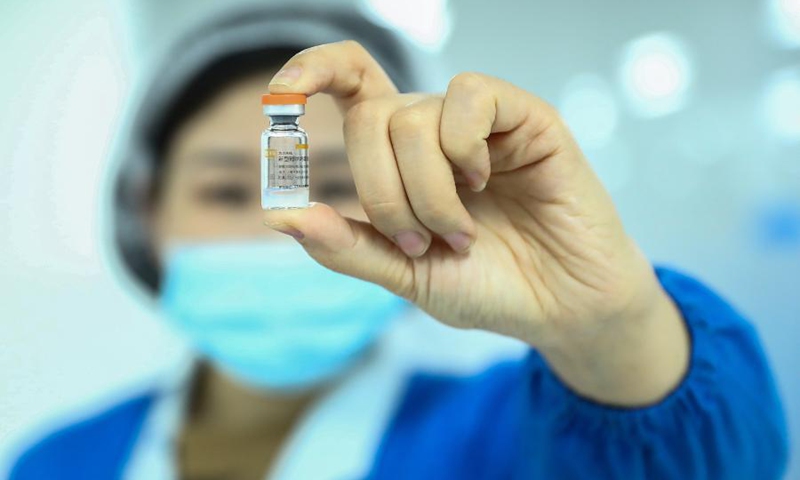 A staff member of Sinovac Biotech, a Chinese biopharmaceutical company, displays a dose of COVID-19 inactivated vaccine in Schering bottle package in Beijing, capital of China, Dec. 23, 2020. Photo: Xinhua