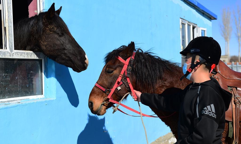 Ulahat Ulan, a senventh grade student of Oymak Boarding School, leads a horse during an equestrian class in Burqin County, northwest China's Xinjiang Uygur Autonomous Region, March 30, 2021. People in Xinjiang Uygur Autonomous Region have a tradition of horse breeding and riding. Photo: Xinhua