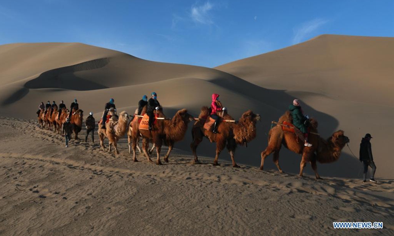 Tourists visit Mingsha Mountain and Yueyaquan (Crescent Spring) scenic spot in Dunhuang City, northwest China's Gansu Province, April 3, 2021. (Xinhua)
