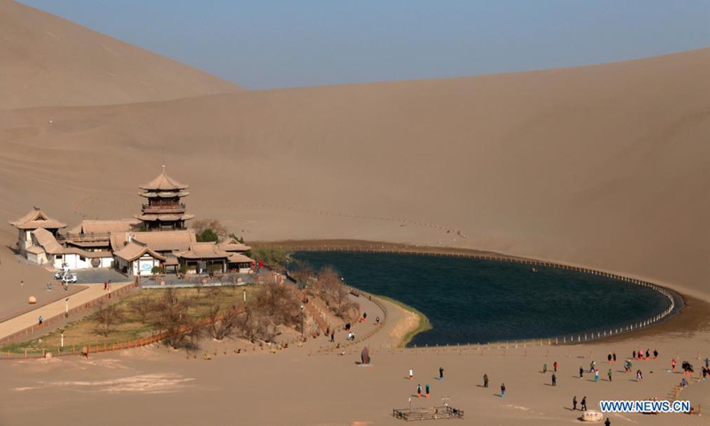 Tourists visit Mingsha Mountain and Yueyaquan (Crescent Spring) scenic spot in Dunhuang City, northwest China's Gansu Province, April 3, 2021. (Xinhua)