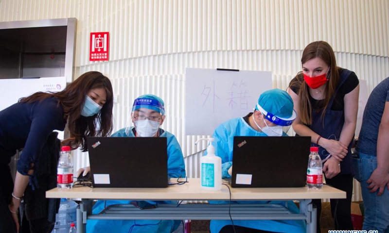 Two foreign recipients (1st L & 1st R) get registered for Sinovac COVID-19 vaccines at a vaccination site in Tsinghua University, Beijing, capital of China, April 3, 2021. Beijing has recently started COVID-19 vaccination for foreign nationals in the city. Foreign nationals aged 18 and above may, following the principle of voluntary participation, giving informed consent and assuming personal responsibility for risk, take the COVID-19 vaccine. (Xinhua)