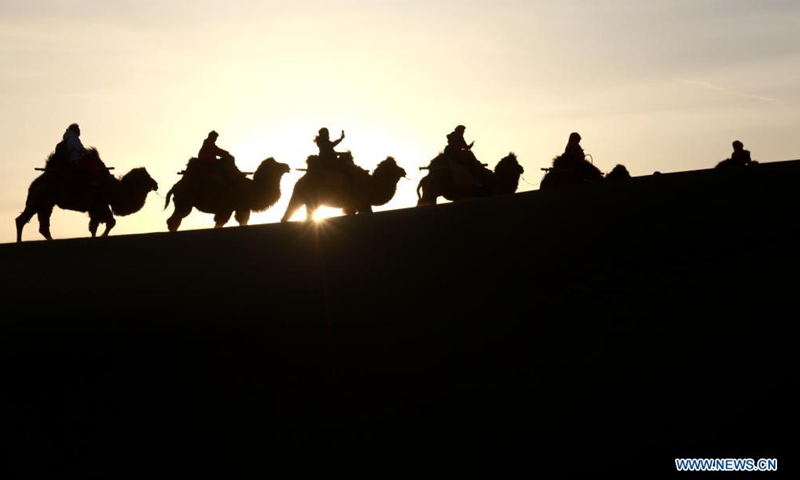 Tourists visit Mingsha Mountain and Yueyaquan (Crescent Spring) scenic spot in Dunhuang City, northwest China's Gansu Province, April 3, 2021. (Xinhua)