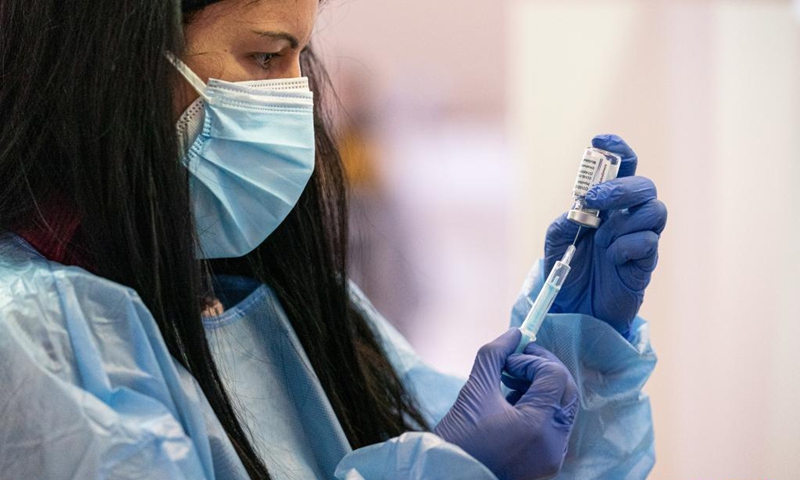A health worker prepares a dose of AstraZeneca COVID-19 vaccine at a vaccination site in Cornella, Spain, April 7, 2021. The European Medicines Agency (EMA) confirmed on Wednesday that the occurrence of blood clots with low blood platelets are strongly associated with the administration of AstraZeneca COVID-19 vaccine, but should be still listed as very rare side effects.(Photo: Xinhua)