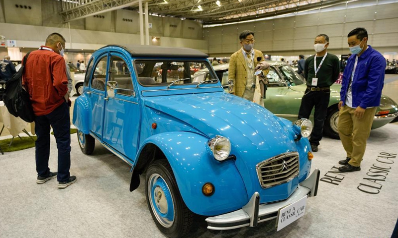 People gather in front of a Citroen 2CV on display during the Automobile Council 2021 car show at Makuhari Messe convention center in Chiba, Japan on April 9, 2021. The show, displaying a wide range of classic vehicles, aims to promote automobile culture and lifestyle in Japan.Photo:Xinhua