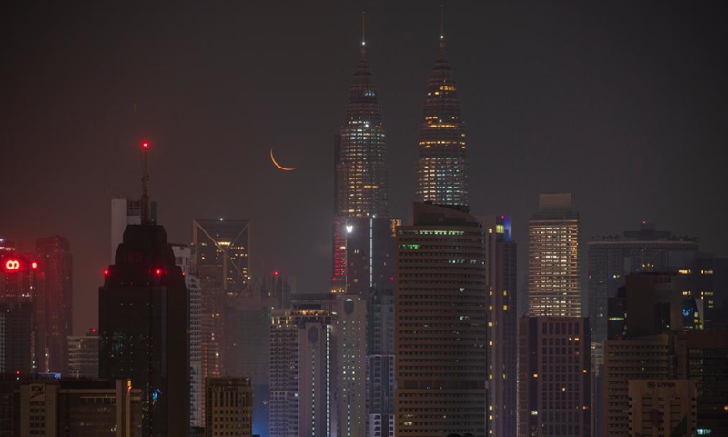A crescent moon is seen in the sky above the city of Kuala Lumpur, Malaysia, April 10, 2021. (Photo by Chong Voon Chung/Xinhua)