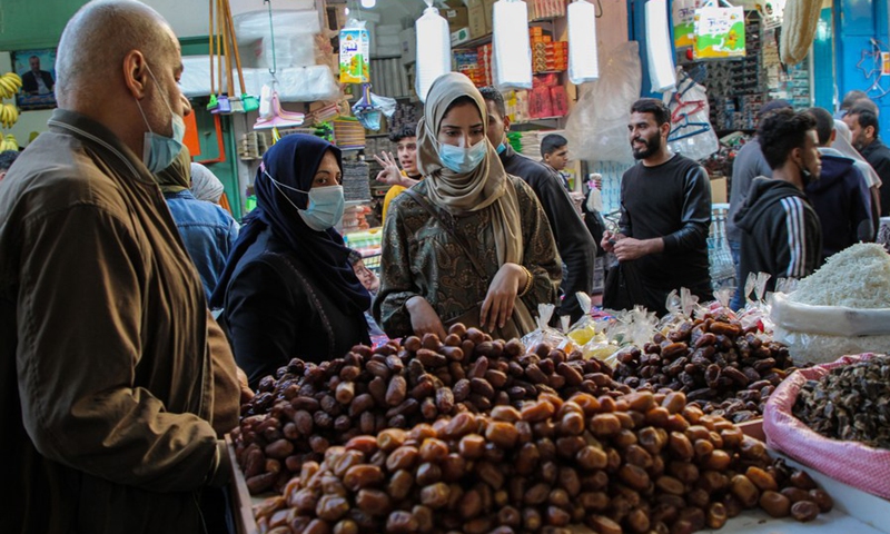 Photo taken on April 12 shows Palestinian women buy dates from a store at al-Zawiya market.(Photo: Xinhua)