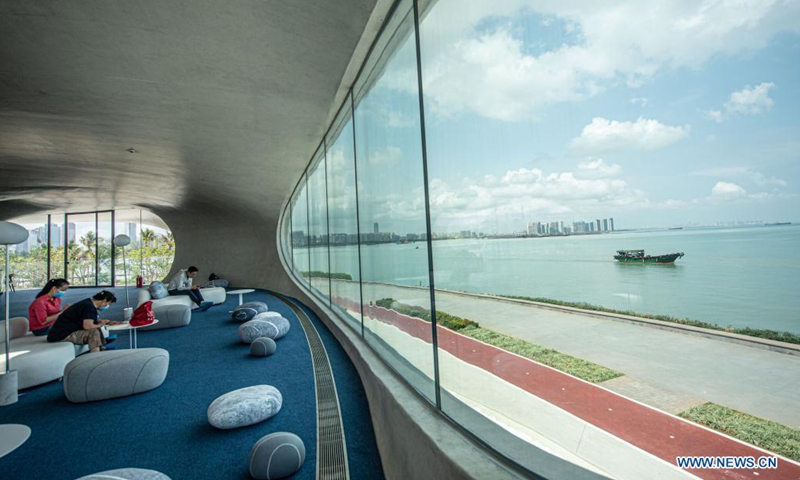 People read and rest at the Wormhole Library in the Haikou Bay in Haikou, capital city of south China's Hainan Province on April 13, 2021. The Wormhole Library, designed as a landmark building in the Haikou Bay, opened to public on Tuesday. (Photo: Xinhua)