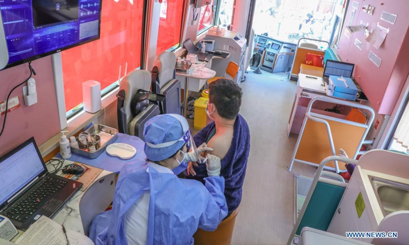 A medical worker injects a man with a dose of COVID-19 vaccine on a mobile vaccination vehicle outside the Donghua Gate of the Palace Museum in Beijing, capital of China, April 13, 2021. The bus-like facilities, equipped with vaccination stations, medical refrigerators and first-aid equipment, have been rolled out in different districts of Beijing to save time and improve inoculation efficiency.(Photo: Xinhua)
