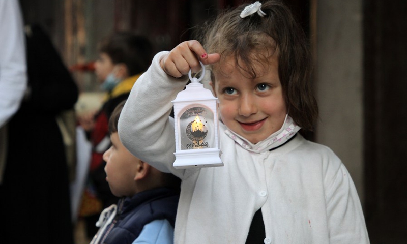 Photo taken on April 12 shows a Palestinian child holds a lantern ahead of Ramadan.(Photo: Xinhua)