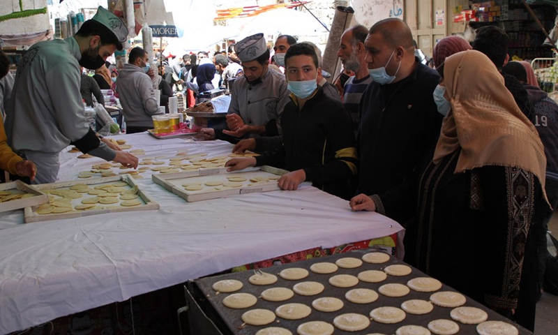 People buy traditional sweets known as Qatayef at a market in the Palestinian enclave of Gaza Strip, on April 13, 2021. (Photo: Xinhua)