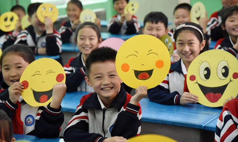 Pupils demonstrate smiley cards to greet the upcoming World Smile Day at a primary school in Handan, north China's Hebei Province, May 7, 2019.(Photo: Xinhua)