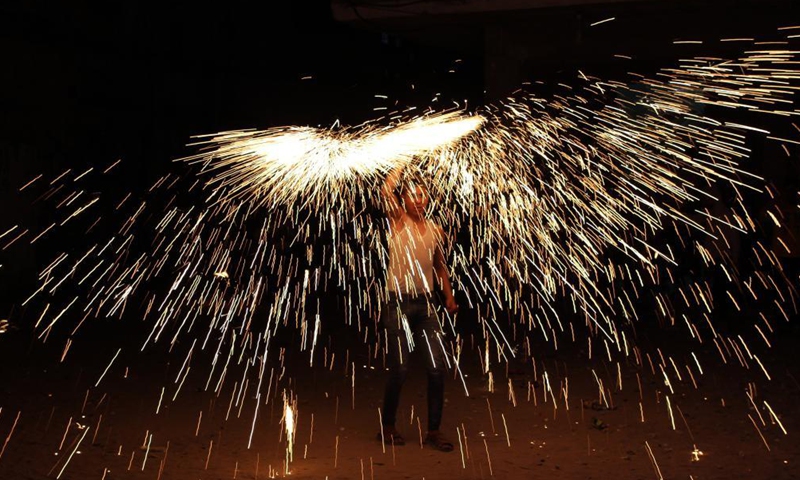 A Palestinian man plays with fireworks during the Islamic holy month of Ramadan in Gaza city, on April 16, 2021.Photo:Xinhua