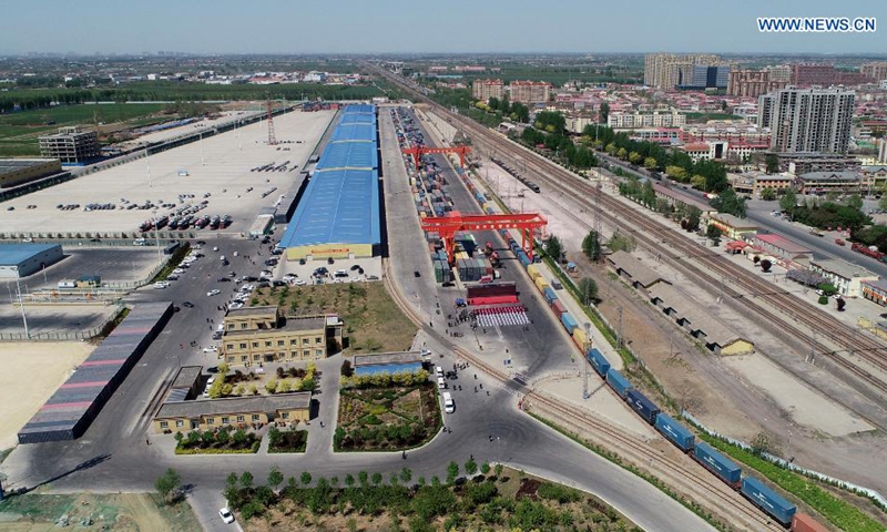 Aerial photo taken on April 17, 2021 shows a freight train bound for Hamburg, Germany departing from the Shijiazhuang international land port in north China's Hebei Province. The first China-Europe freight train bound for Germany from Hebei Province set out on Saturday in Shijiazhuang. The train, loaded with 100 twenty-foot equivalent unit (TEU) of cargo, is expected to arrive in Hamburg in 18 days.(Photo: Xinhua)