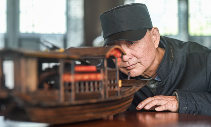 Han Minghua checks a Red Boat model at the workshop of Jiaxing Minghua Ship Model Manufacturing Co., Ltd. in Yuxin Town of Jiaxing City, east China's Zhejiang Province, April 13, 2021.(Photo: Xinhua)