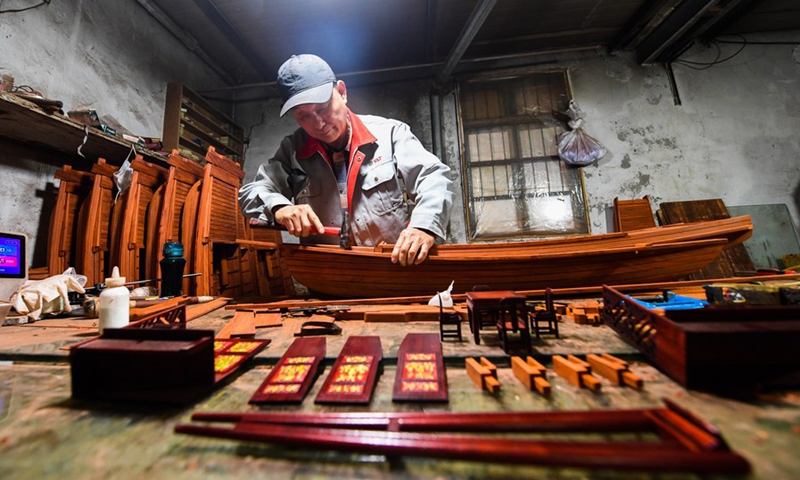 Han Minghua makes a model of the Red Boat at the workshop of Jiaxing Minghua Ship Model Manufacturing Co., Ltd. in Yuxin Town of Jiaxing City, east China's Zhejiang Province, April 13, 2021.(Photo: Xinhua)