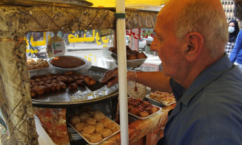 A sweets cart owner is seen in a popular market in Tripoli, the second largest city of Lebanon, on April 19, 2021. (Photo: Xinhua)