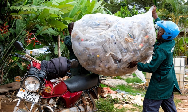 Workers of Eco Ways Uganda place a sack of reusable plastic bottles on a motor bike in Kampala, Uganda, April 16, 2021.(Photo: Xinhua)