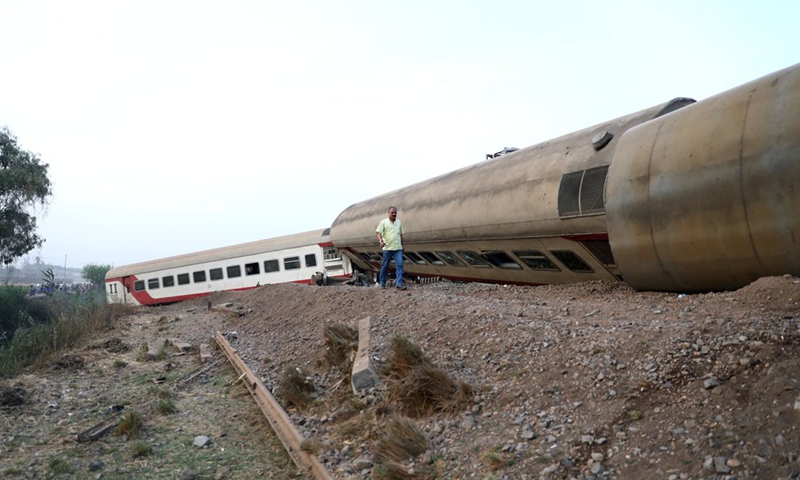 A man walks past a derailed train in the Delta city of Toukh, Egypt, on April 18, 2021.(Photo: Xinhua)